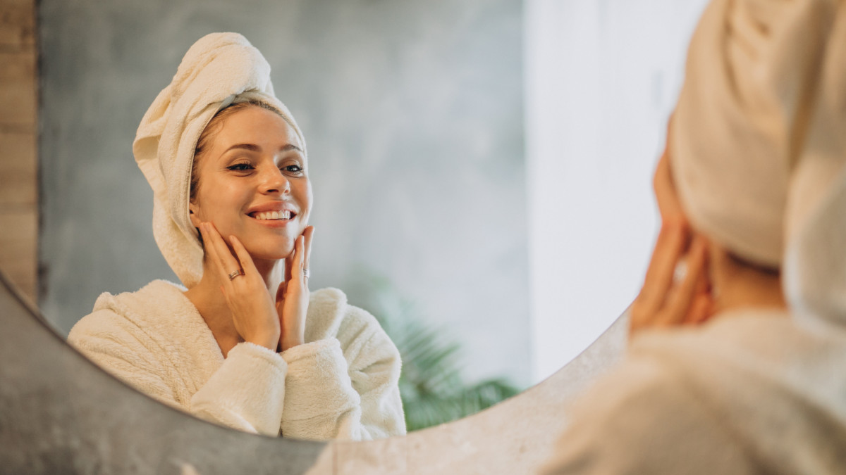 Quel soin du visage privilégier pour retrouver de l’éclat en 2026 ? 1 une jeune femme admire sa peau éclatante dans un miroir